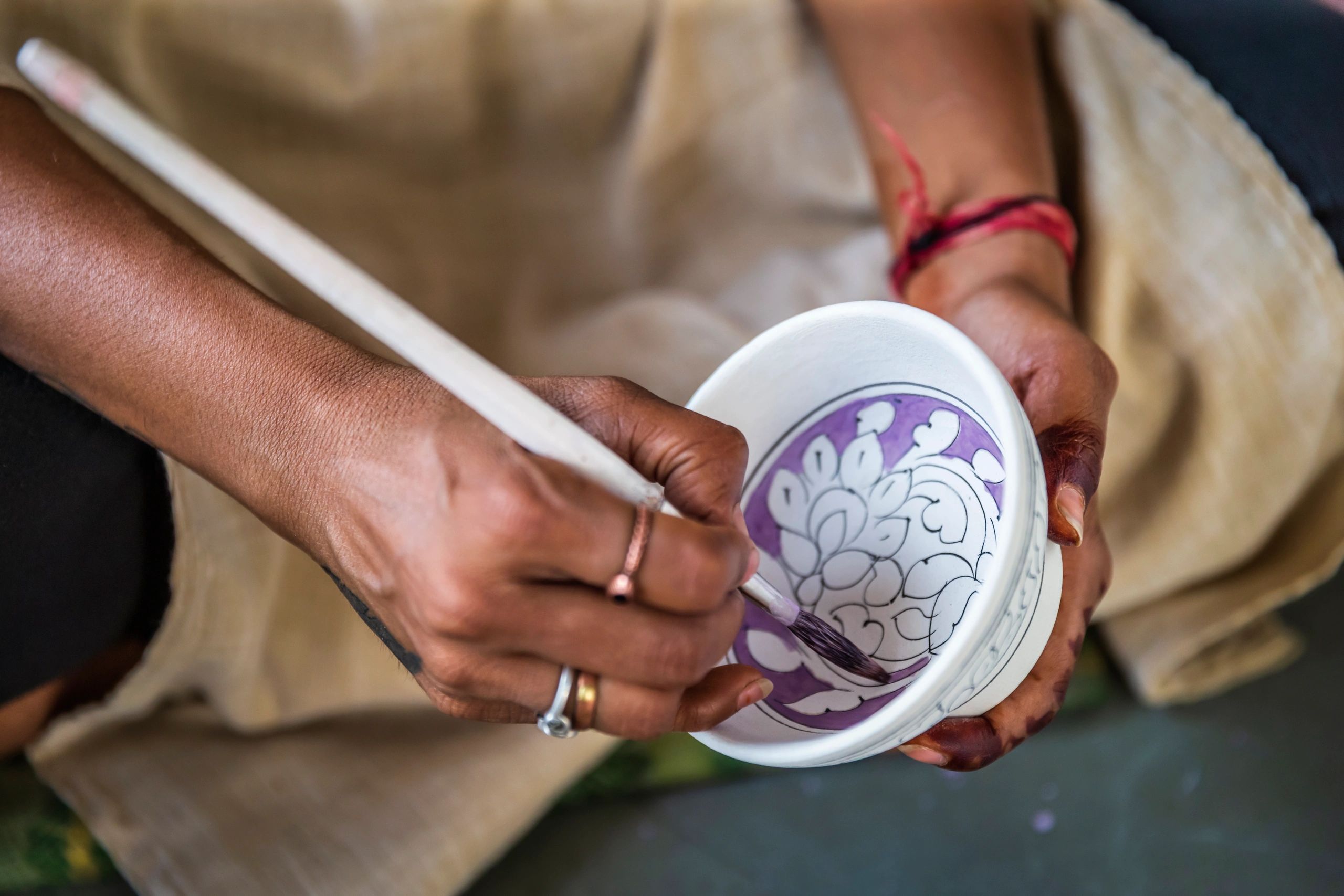 Artisan hand-painting handcrafted pottery in India